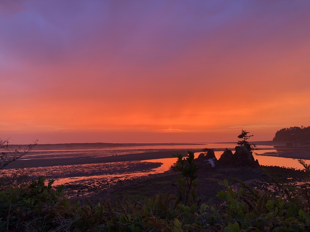 An orange sunset on the Oregon Coast with a hint of blue sky at the top of the image